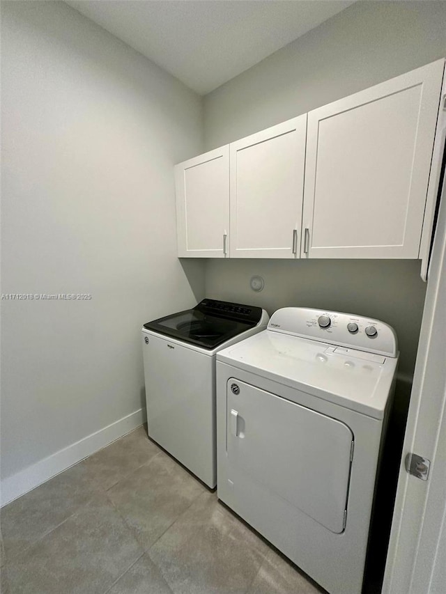 laundry room featuring cabinets and washer and clothes dryer