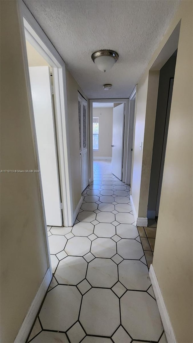 hall featuring a textured ceiling