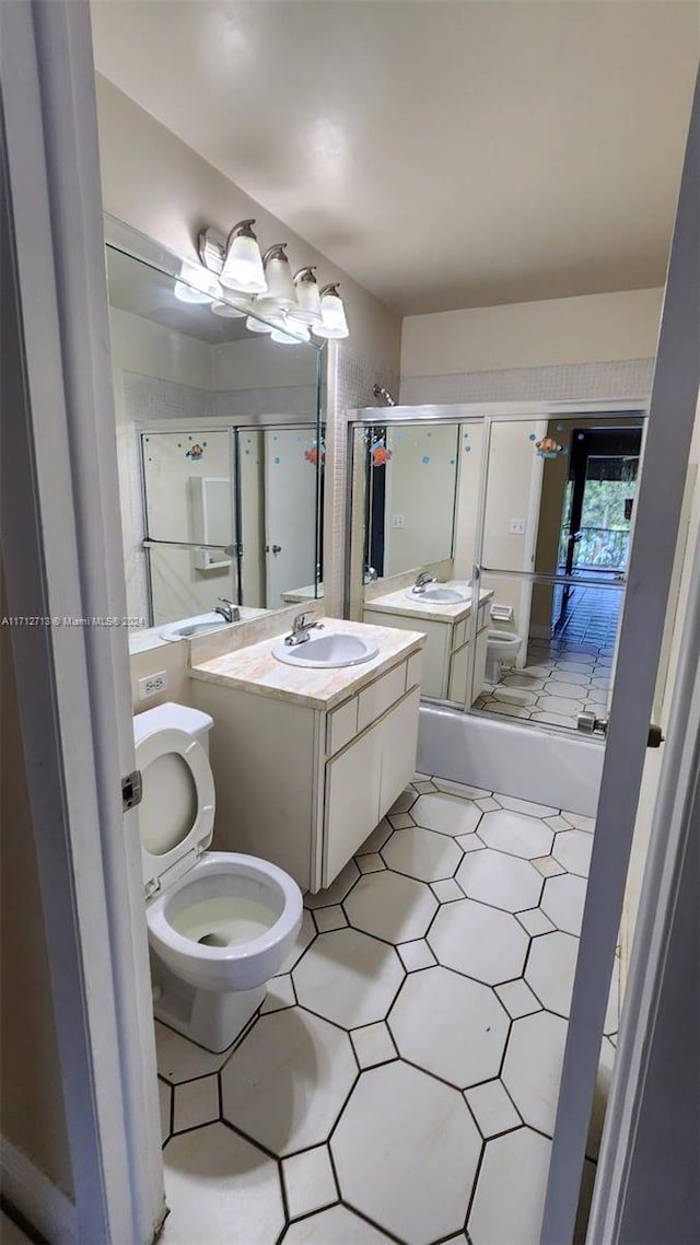 full bathroom with tile patterned flooring, toilet, vanity, and combined bath / shower with glass door