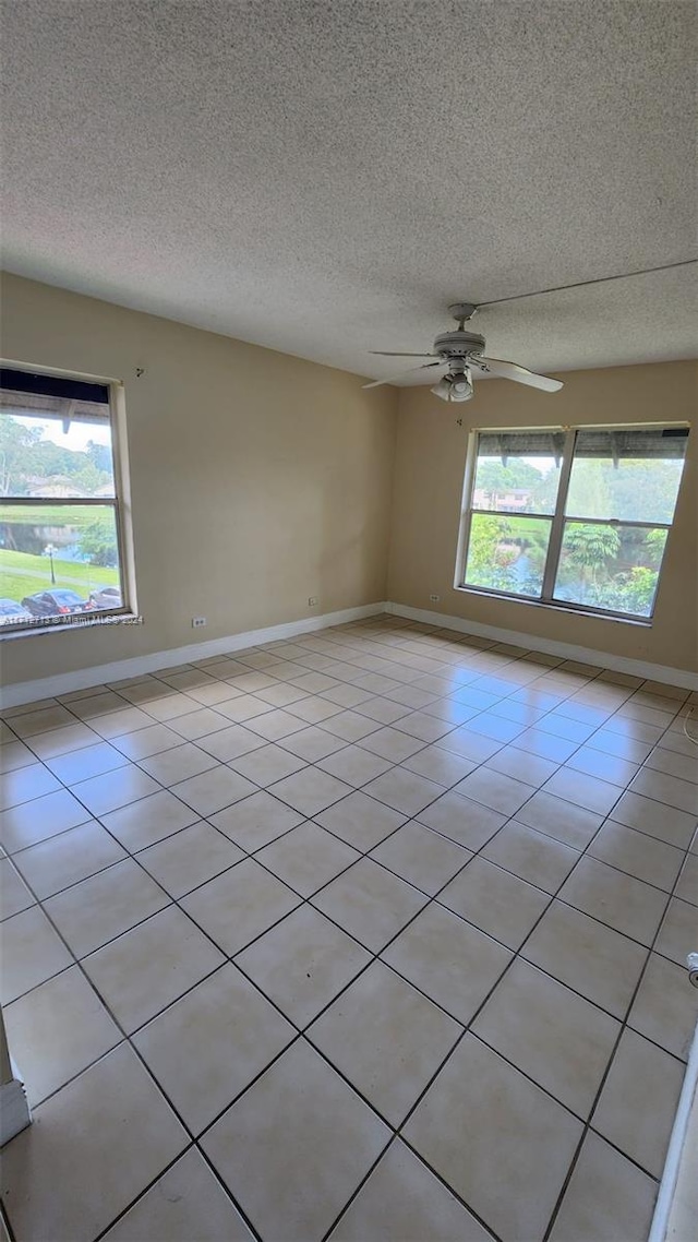 unfurnished room with a textured ceiling, ceiling fan, and light tile patterned flooring