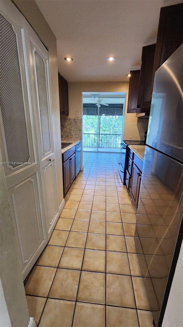 kitchen featuring dark brown cabinetry, light tile patterned floors, and appliances with stainless steel finishes