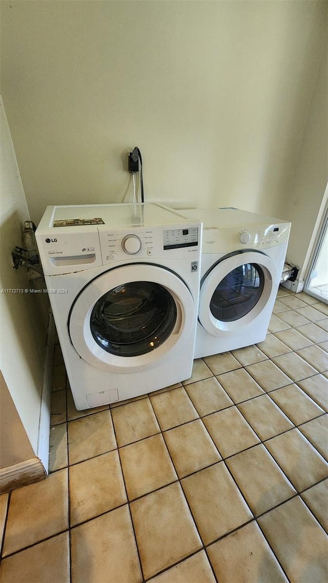 clothes washing area with light tile patterned floors and separate washer and dryer