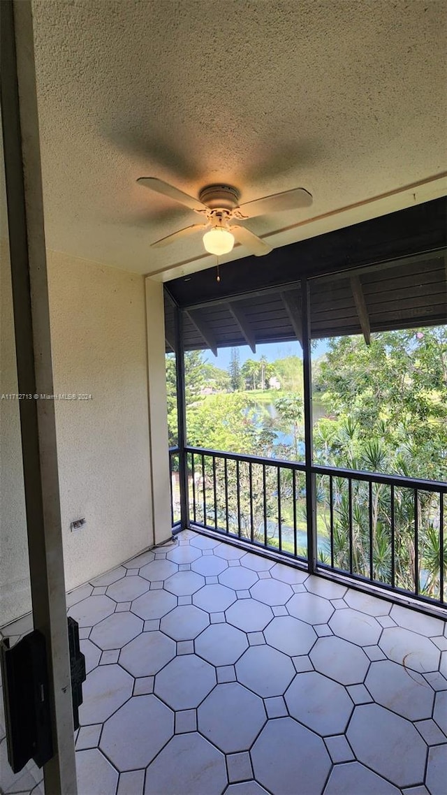 unfurnished sunroom featuring ceiling fan