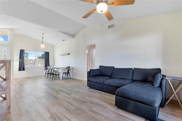 living room with ceiling fan, light hardwood / wood-style flooring, and a textured ceiling