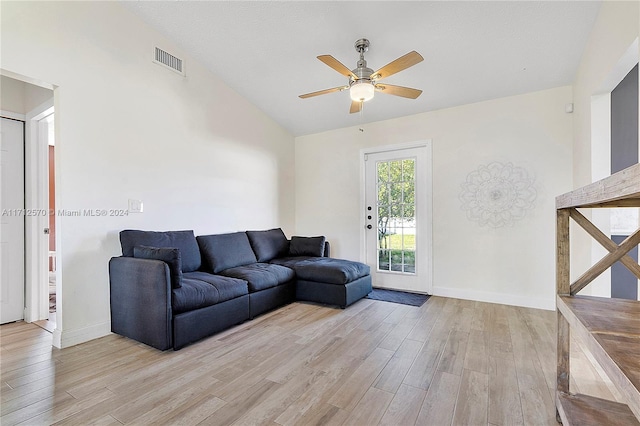 living room featuring ceiling fan, vaulted ceiling, and light wood-type flooring