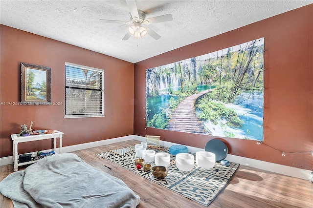 dining area with hardwood / wood-style flooring, ceiling fan, and a textured ceiling