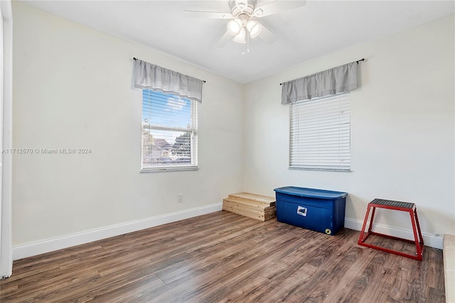 empty room with dark hardwood / wood-style flooring and ceiling fan