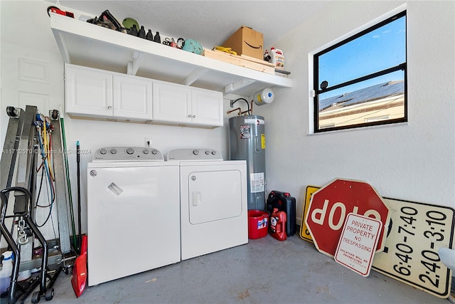 laundry area featuring electric water heater, cabinets, and washer and dryer