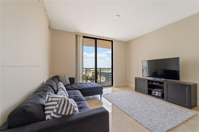 living room with a textured ceiling and a wall of windows