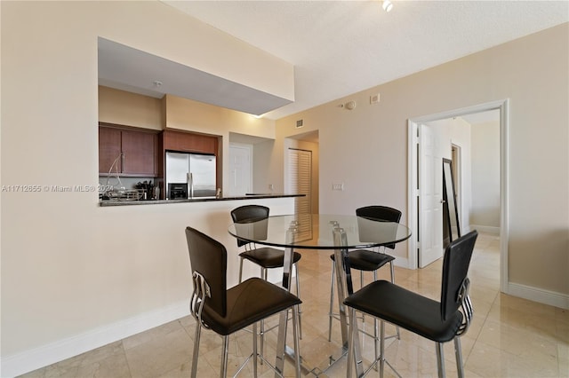 tiled dining room with a textured ceiling