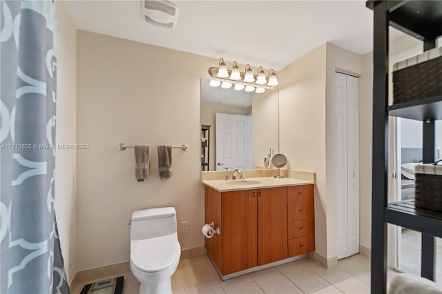 bathroom with tile patterned flooring, vanity, and toilet