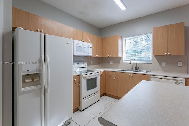 kitchen featuring sink, light tile patterned flooring, and white appliances