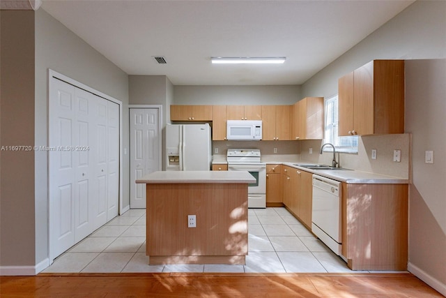 kitchen with a kitchen island, white appliances, sink, and light tile patterned floors