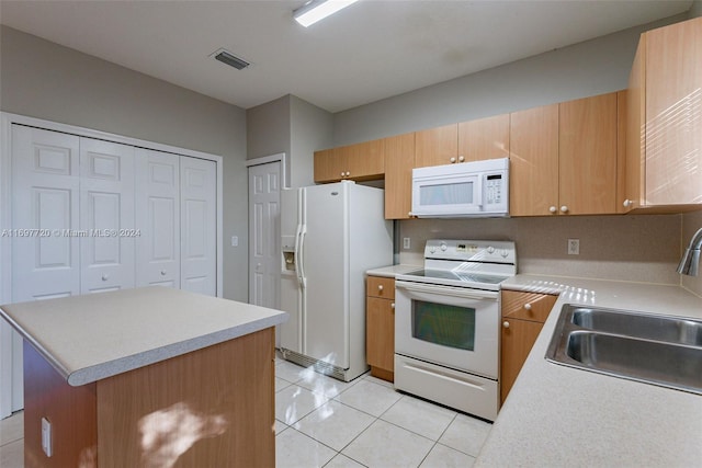 kitchen with a center island, white appliances, sink, and light tile patterned floors