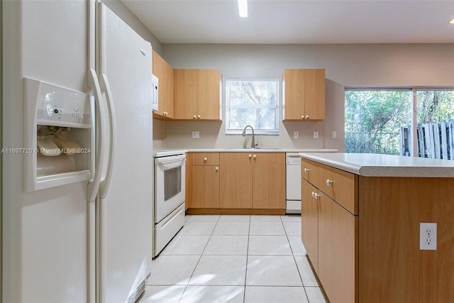 kitchen featuring sink, light tile patterned flooring, and white appliances