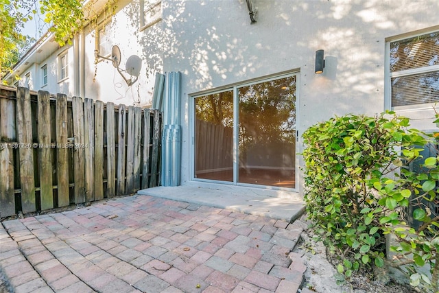 view of exterior entry featuring a patio