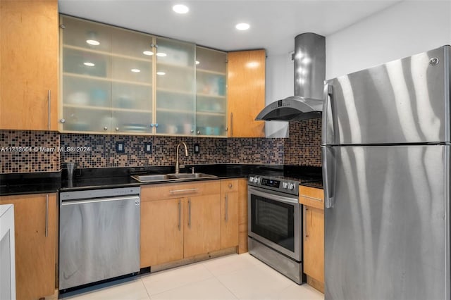 kitchen with appliances with stainless steel finishes, sink, tasteful backsplash, and wall chimney range hood