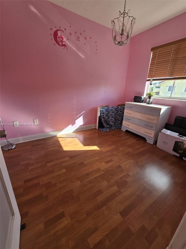 bedroom featuring a chandelier and dark wood-type flooring