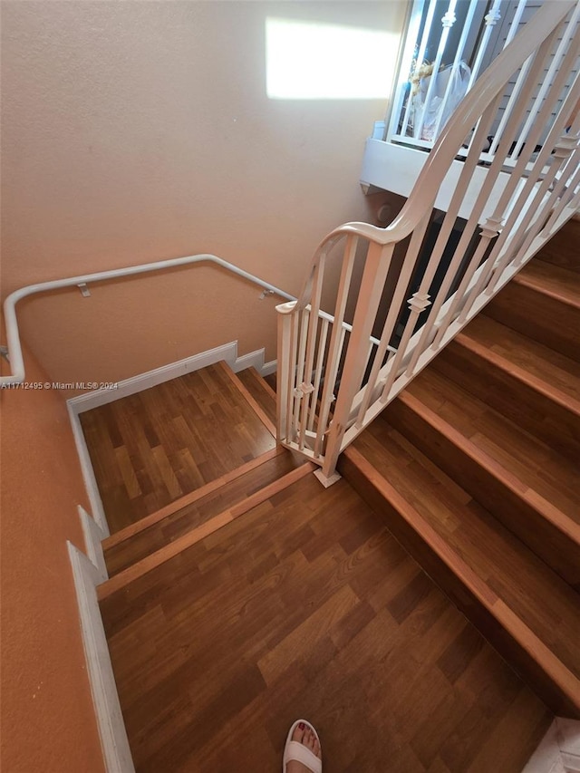 staircase featuring wood-type flooring