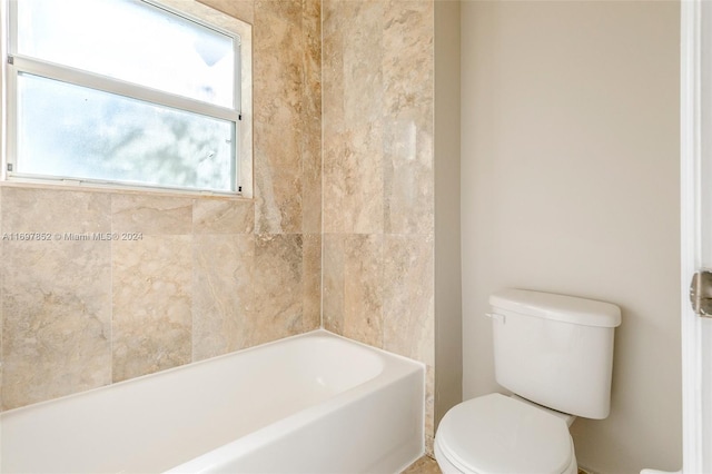 bathroom featuring a washtub and toilet