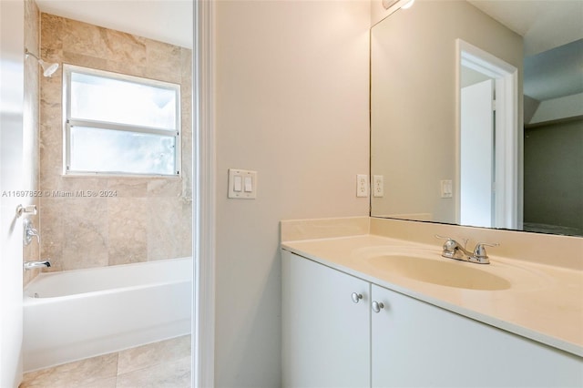 bathroom with tile patterned flooring, vanity, and tiled shower / bath