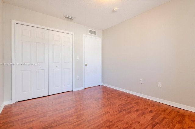 unfurnished bedroom featuring hardwood / wood-style floors and a closet