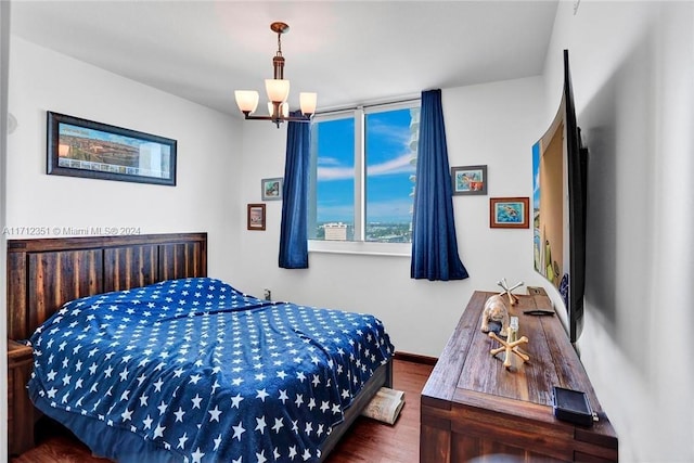 bedroom featuring hardwood / wood-style flooring and a chandelier