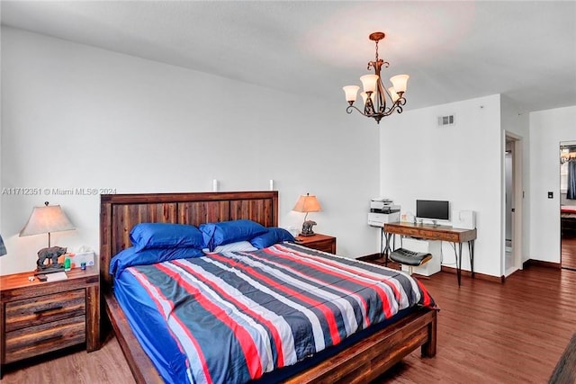 bedroom with dark hardwood / wood-style flooring and a chandelier