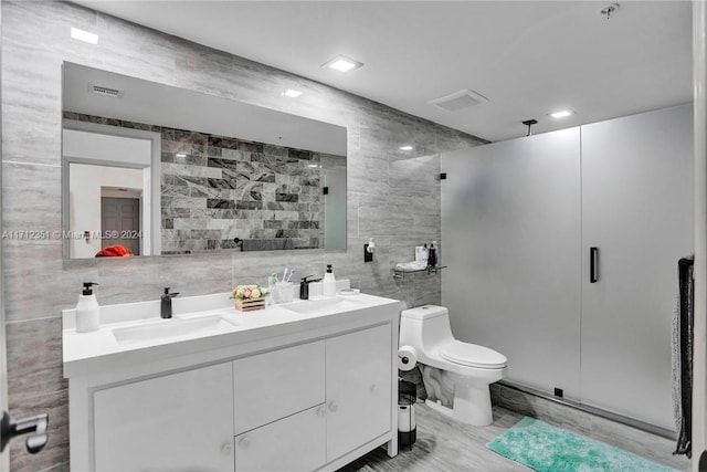 bathroom with vanity, tile walls, and toilet