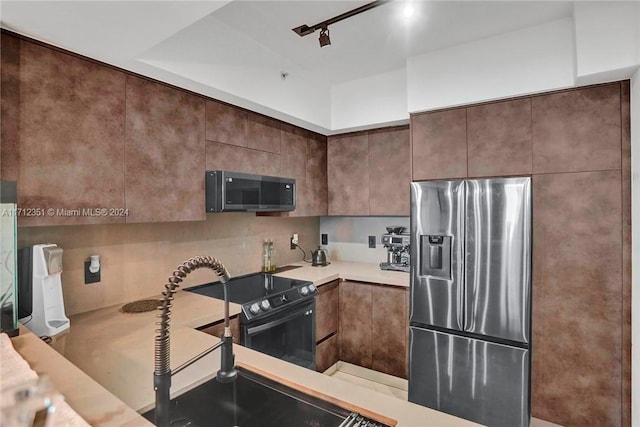 kitchen with electric stove, stainless steel fridge, and rail lighting