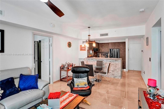 living room featuring ceiling fan with notable chandelier