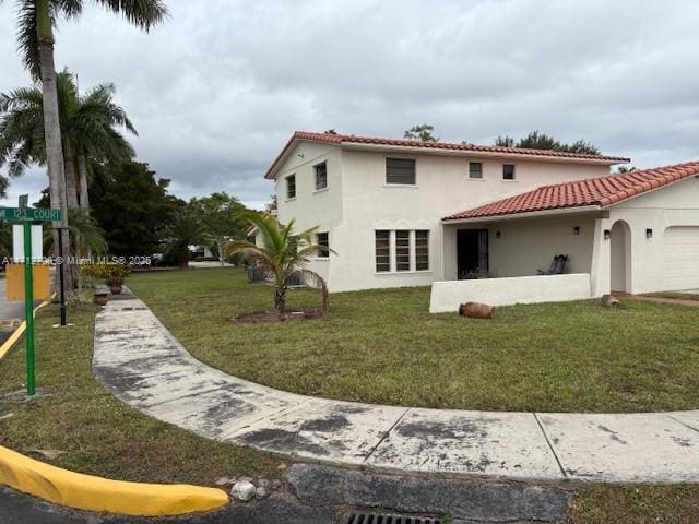 back of house featuring a garage and a yard