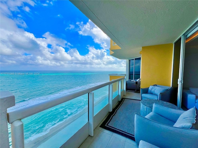 balcony featuring an outdoor living space and a water view