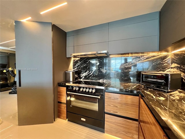 kitchen with backsplash, black gas stove, ventilation hood, and dark stone countertops