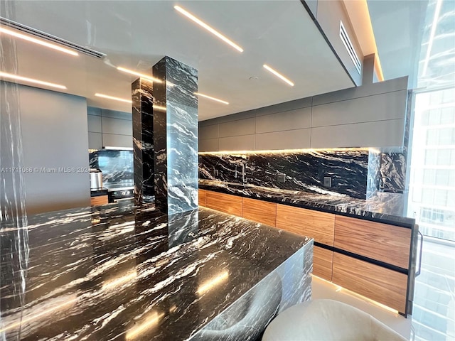 kitchen with tasteful backsplash and dark stone counters