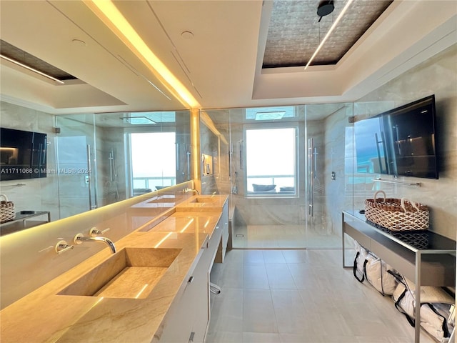 bathroom featuring a raised ceiling, vanity, and an enclosed shower