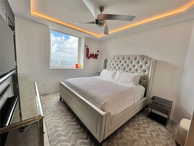 bedroom featuring a raised ceiling and ceiling fan