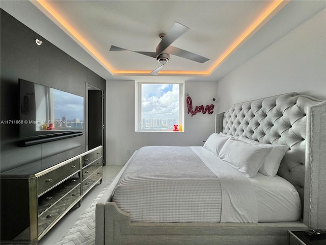 bedroom with a raised ceiling and ceiling fan