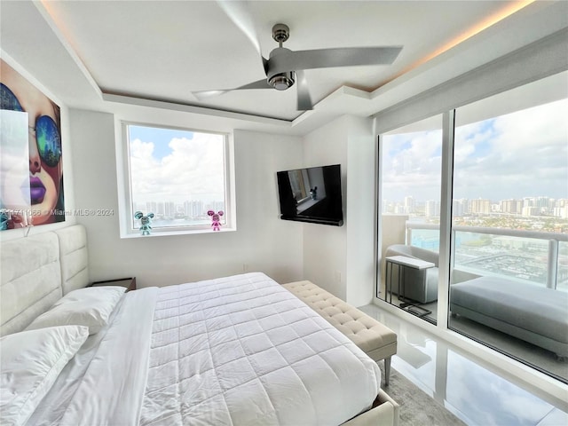 bedroom with multiple windows, access to exterior, and ceiling fan