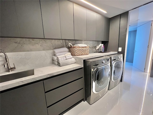 laundry room with cabinets, sink, and washing machine and clothes dryer