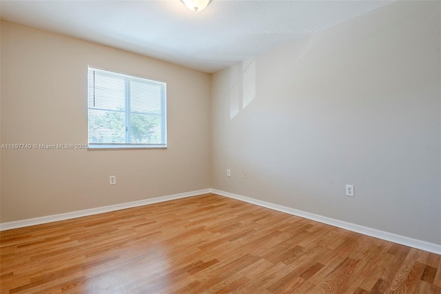 empty room with baseboards and light wood-style floors