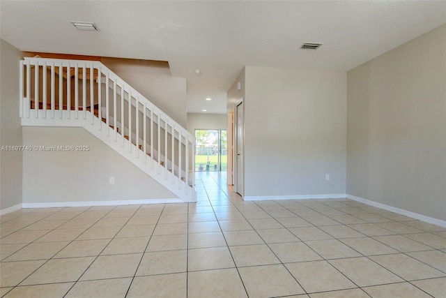 unfurnished room featuring stairs, light tile patterned flooring, baseboards, and visible vents