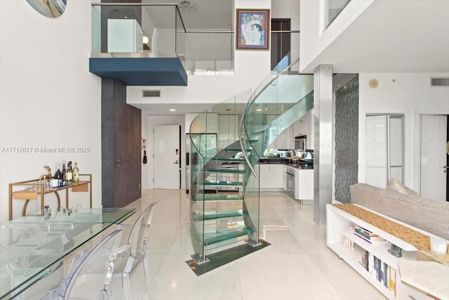 stairway featuring tile patterned floors and a high ceiling