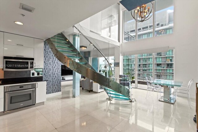 kitchen with light tile patterned floors, white cabinetry, and appliances with stainless steel finishes