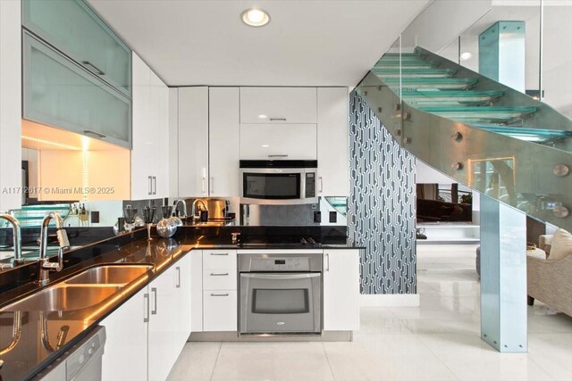 kitchen with white cabinets, light tile patterned floors, and appliances with stainless steel finishes