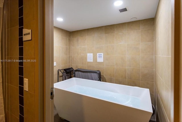 bathroom with tile walls and a washtub