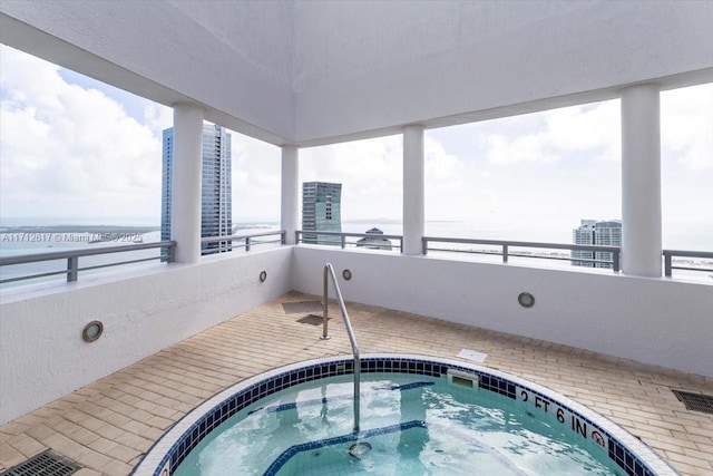 view of pool featuring a community hot tub and a water view