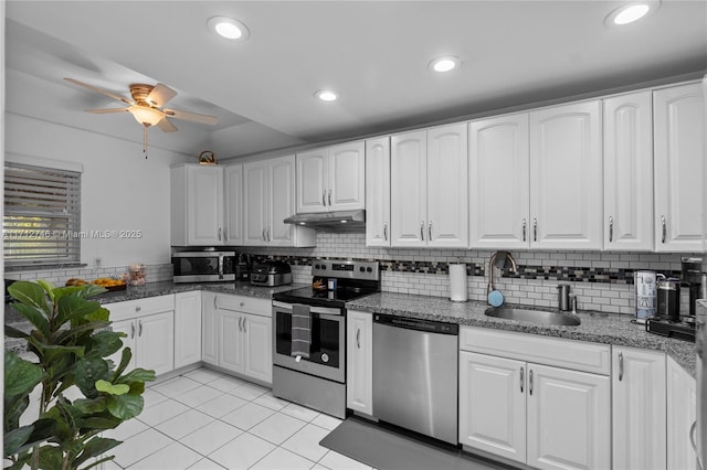 kitchen with white cabinetry, stainless steel appliances, sink, backsplash, and light tile patterned floors