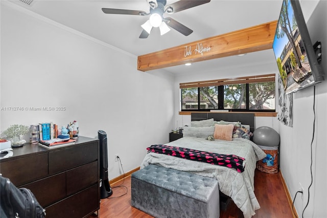 bedroom with ceiling fan, beamed ceiling, wood-type flooring, and ornamental molding