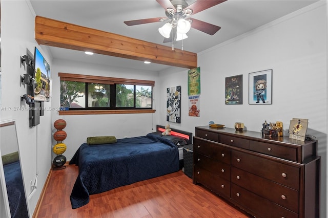 bedroom with ceiling fan, crown molding, light hardwood / wood-style floors, and beam ceiling